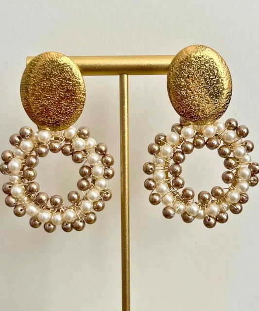 Aros circulares con técnica de alambrismo fino en Perlas shell, marfil y doradas, únicas y elegantes. Tanto la base como el gancho son de acero inoxidable para no dañar la piel de la oreja.