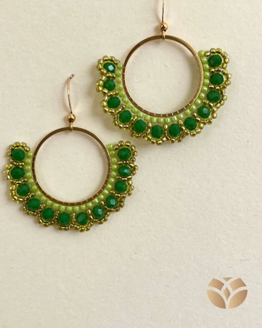 Inspirados en la elegancia sutil de una flor, estos aros están completamente tejidos a mano con la técnica del peyote , una tradición milenaria de precisión y paciencia.

Cada pieza combina:
Mostacillas en verde pistacho y dorado
Cristales chatos verde oscuro que capturan la luz
Base en acero inoxidable, ideal para pieles sensibles.