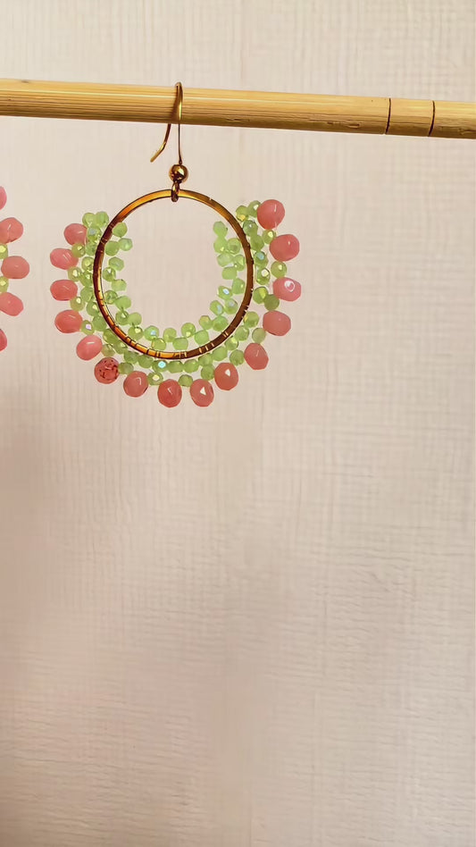 Aros tejidos Mía-Cristales en tono verde pistacho y Piedras Agata rosa, tejidos con técnica peyote, base y gancho en acero inoxidable.